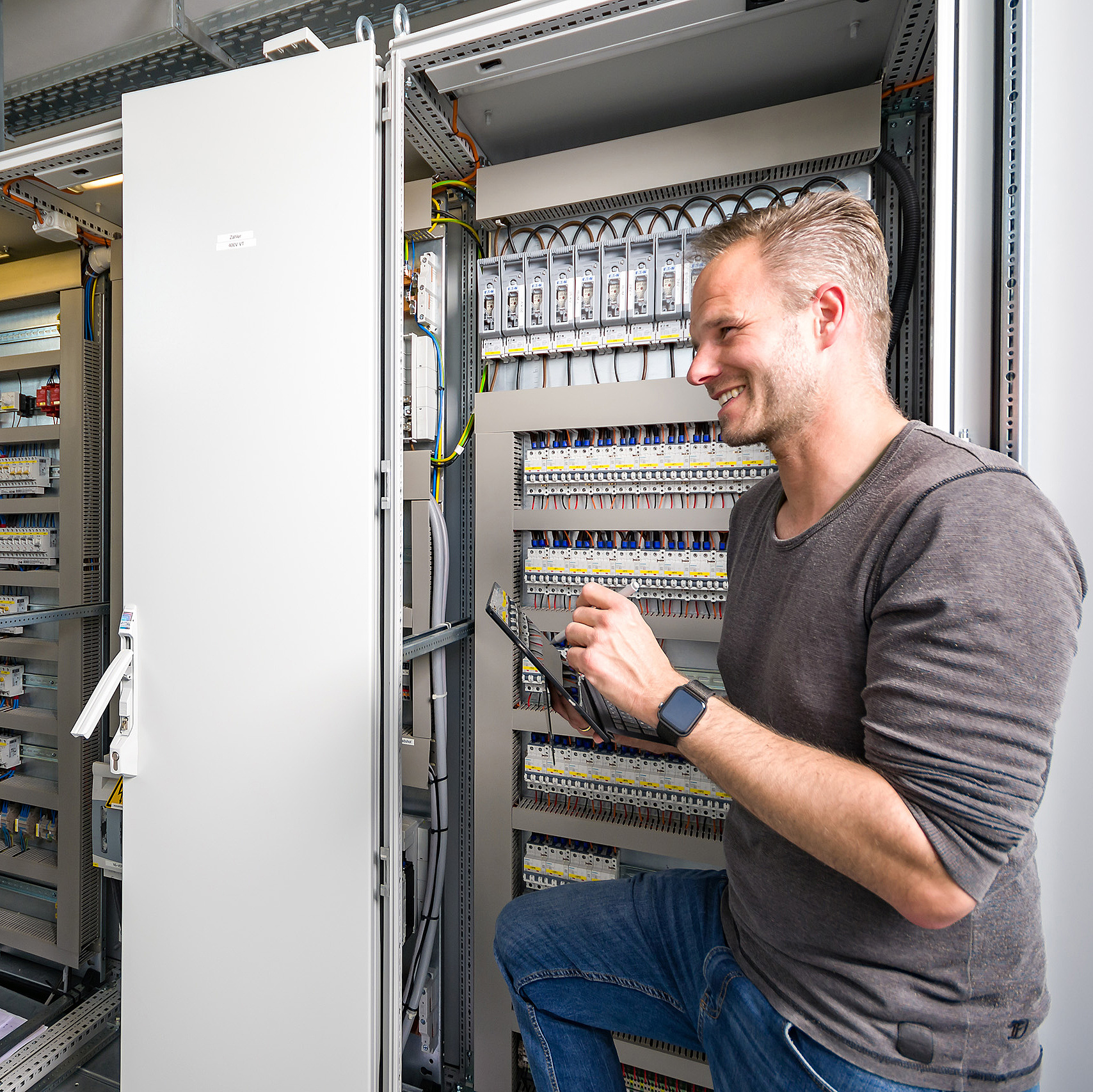 Elektriker steht vor Verteilerkasten