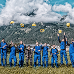 Gruppenbild Lehrlinge werfen im Freien ihre Helme in die Luft